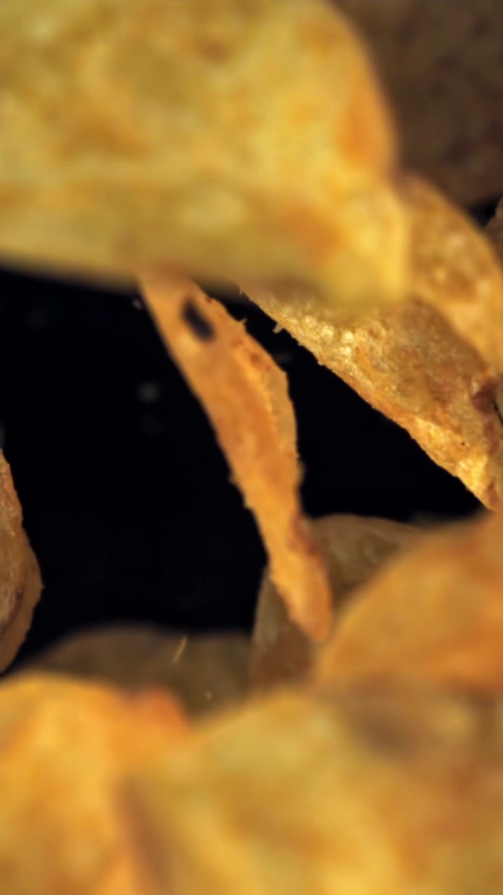 Golden Crispy Potato Chips Falling in Slow Motion