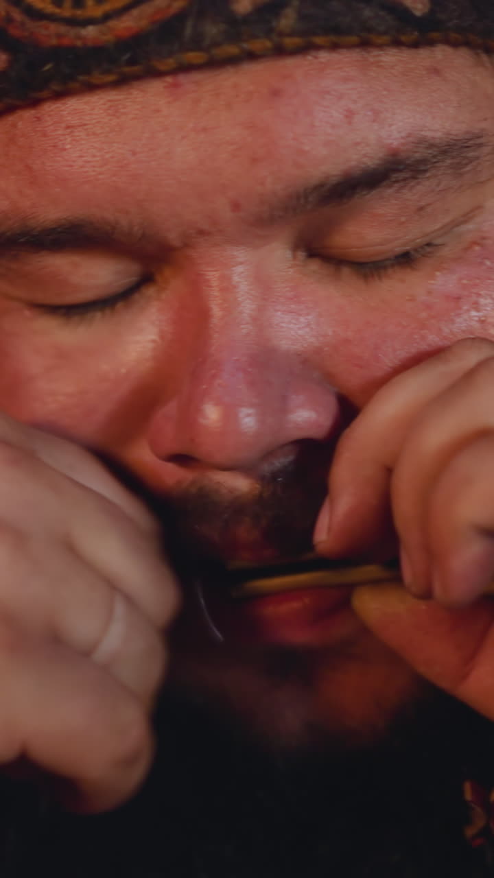 Meditating man in Altai national clothes plays vargan conducting mystical ritual at festival closeup. Mouth musical instrument on Siberian folks