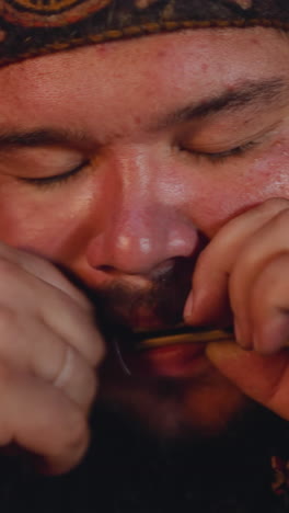 meditating man in altai national clothes plays vargan conducting mystical ritual at festival closeup. mouth musical instrument on siberian folks