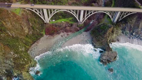 overhead aerial view of a car driving over bixby creek bridge in big sur on state route 1 in california