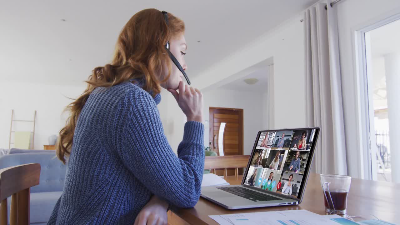 mujer caucásica usando portátil y auriculares de teléfono en videollamada con colegas
