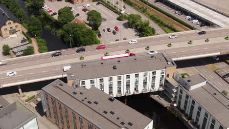Industrial-chimney-and-street-traffic-of-Swedish-town,-aerial-drone-view