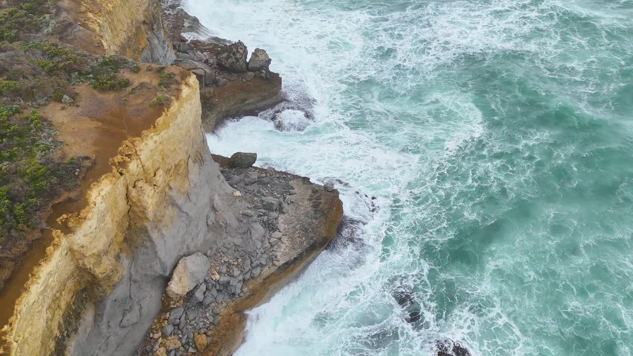 Drone captures stunning cliffs and turquoise waves at Port Campbell, Australia, highlighting natural beauty and rugged coastline