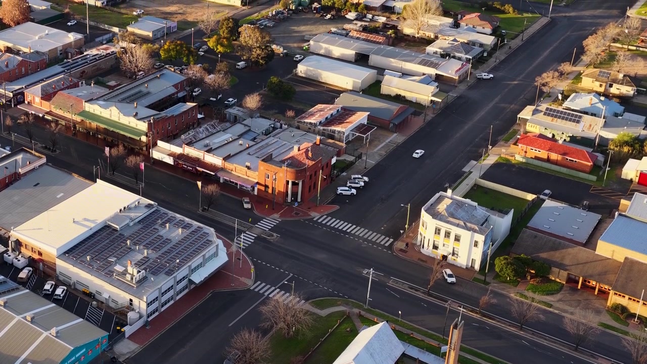 Ripresa aerea con drone di un tranquillo incrocio di una città dell'outback durante l'ora d'oro in Australia.