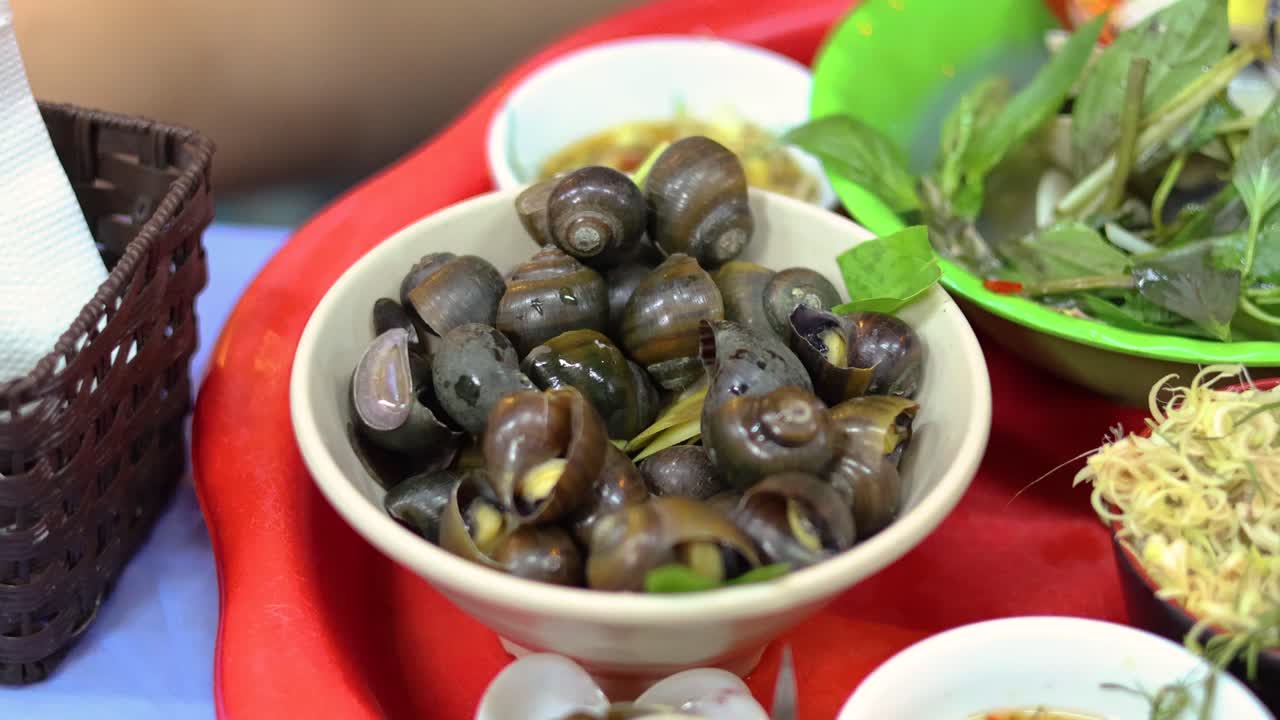 mostrando un cuenco de caracoles vietnamitas con hierbas