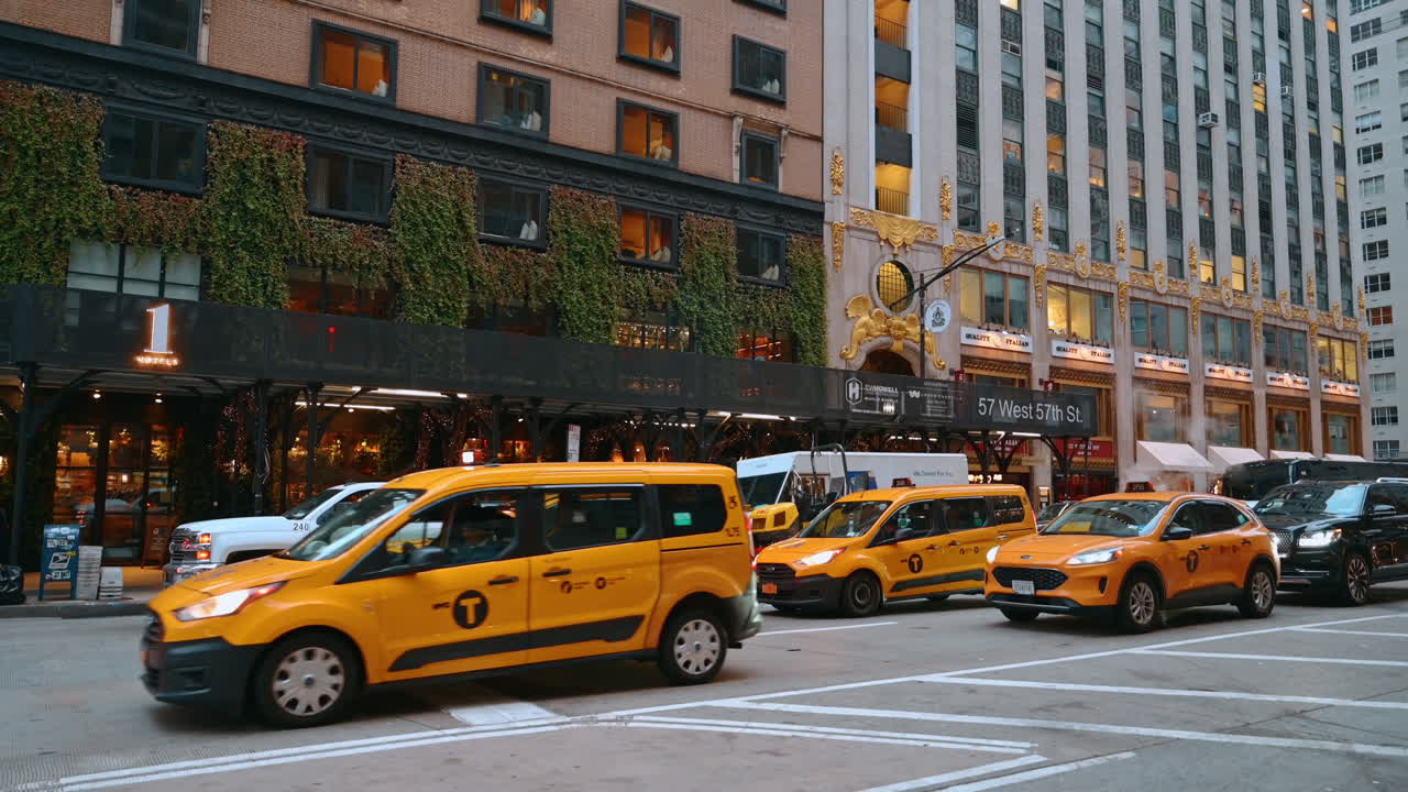New York, USA, 22 October 2025: Yellow taxi cars stand in the transport flow at the crossroads. Lively traffic by the street of New York, USA
