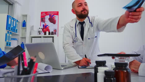 hombre médico dando radiografía a un compañero de trabajo mayor