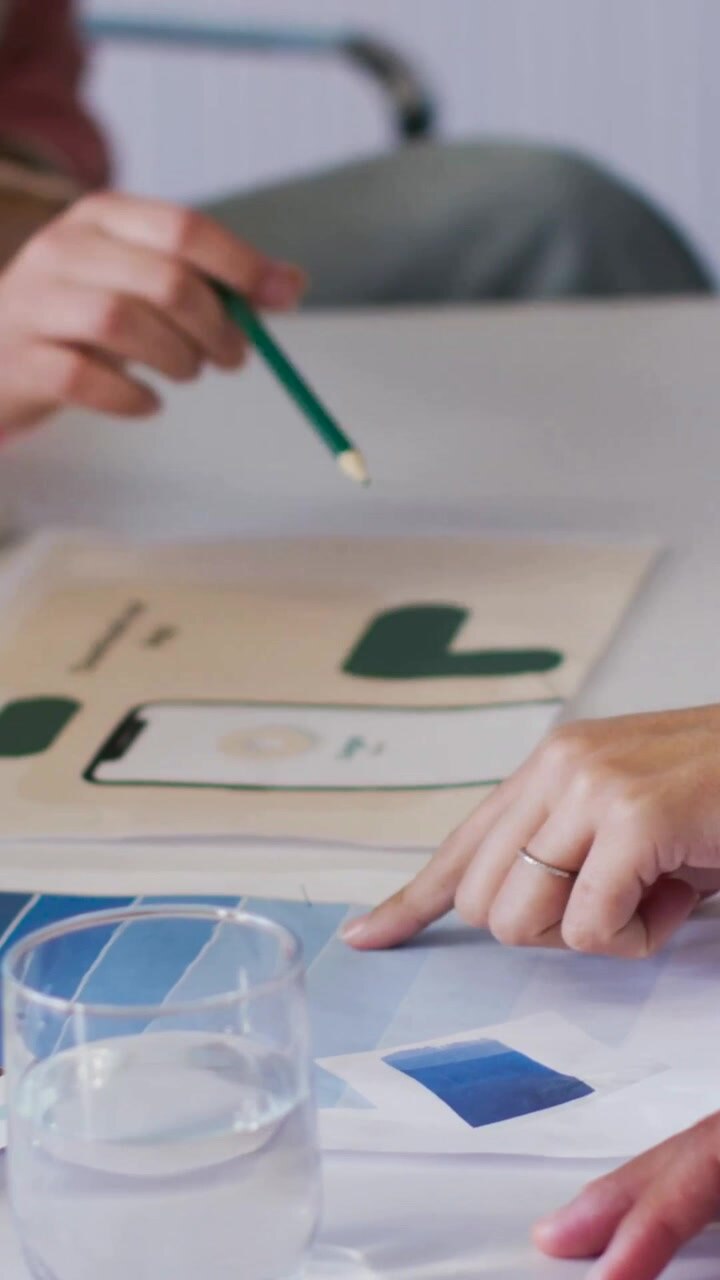Vertical video: Hands pointing at mockup chips at table, selecting color with green pencil pink top