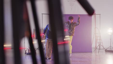 portrait of happy biracial male dancers dancing in dance studio, slow motion