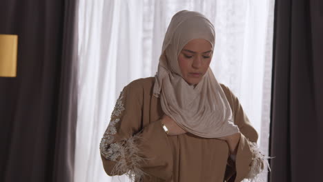 mujer musulmana con hijab en casa orando y inclinándose