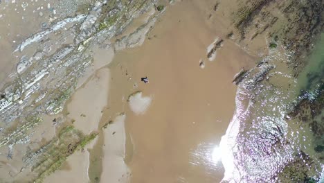 Aerial-Over-A-Man-Walking-Through-Ocean-Tide-Pools-Along-The-Central-Coast-Of-California-Near-Santa-Barbara-2