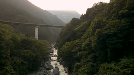 aerial tilting down over river in rural japan on the island of shikoku in the tokushima prefecture