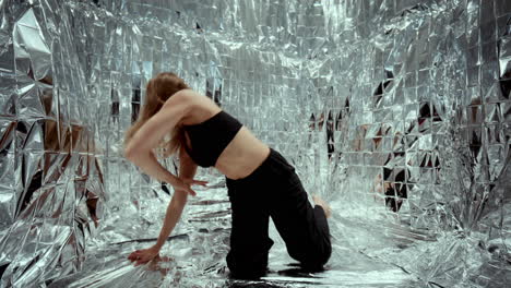dancer giving experimental contemporary performance on silver surface