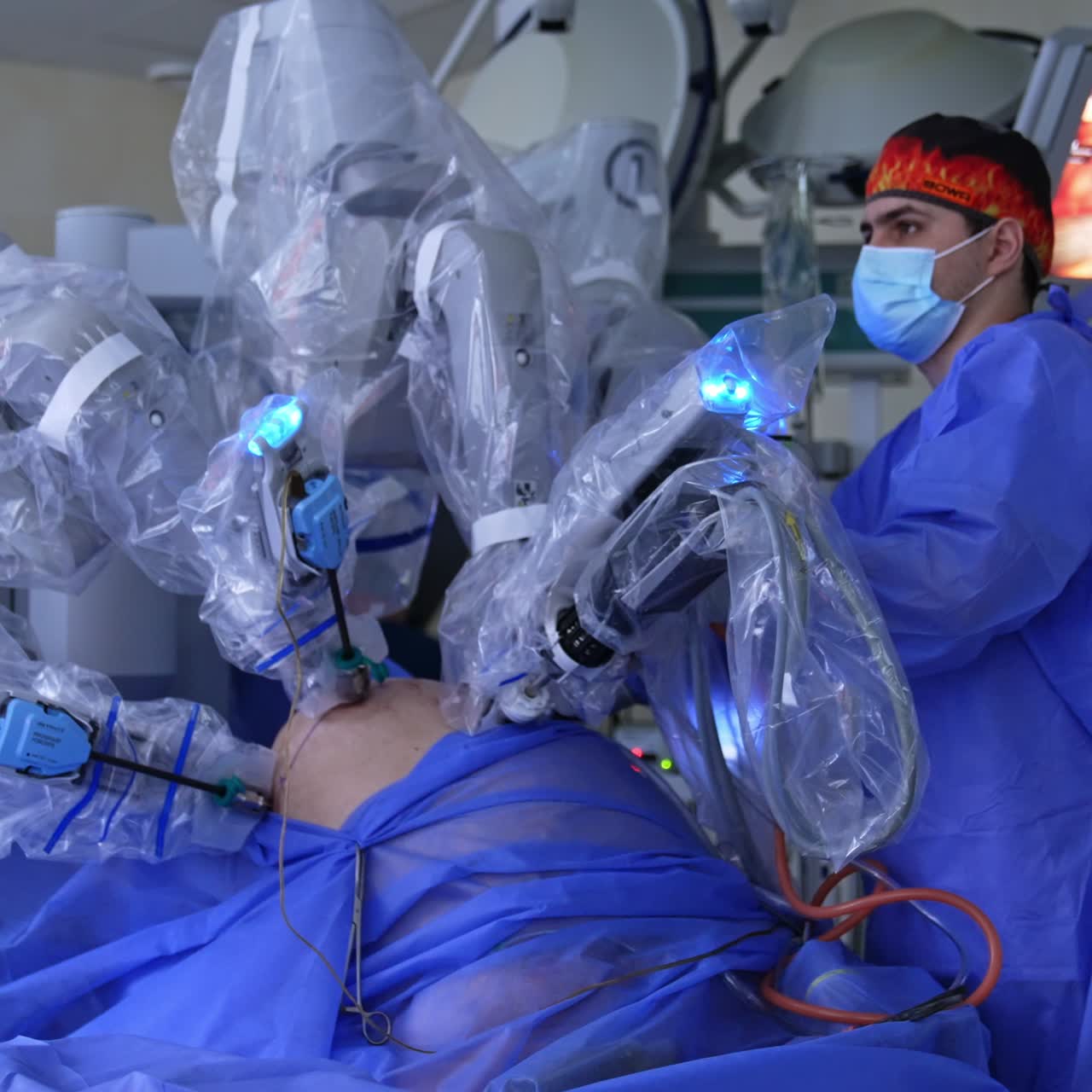Modern surgical room with robotic surgical equipment. Da Vinci surgeon performs operation controlled by the male doctor