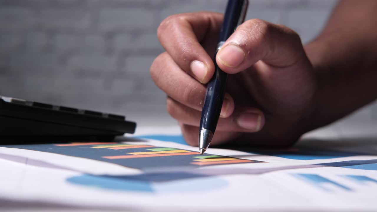 mano analizando un gráfico con un bolígrafo