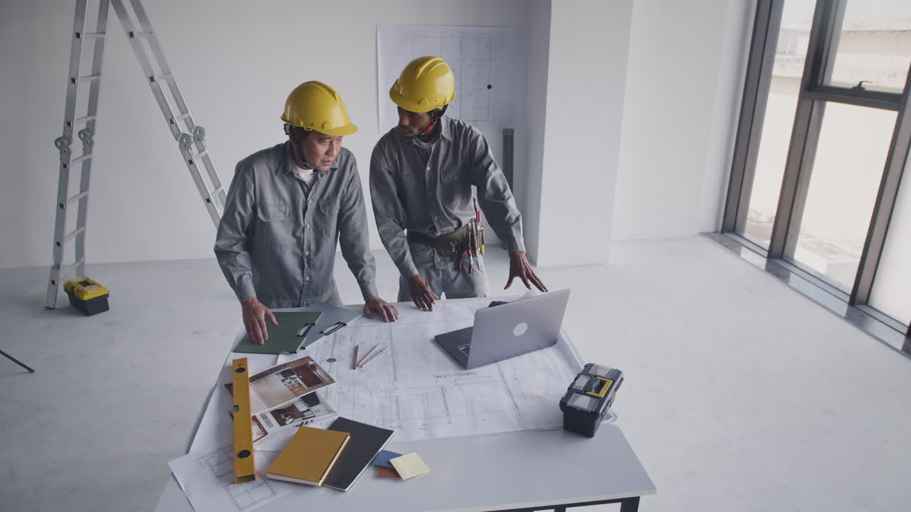 Construction Workers Planning Work with Building Blueprint