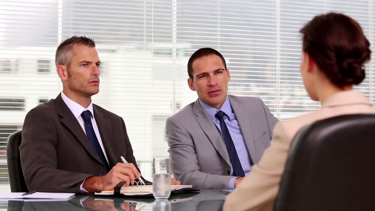 사업가들이 신청자와 대화하고 있습니다.