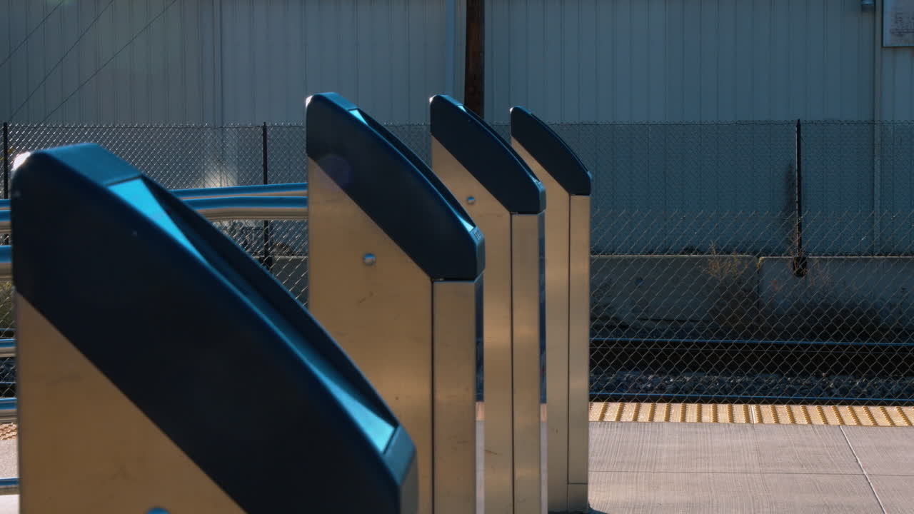 People scanning their badges for a commuter train.  Finishing a days work.  Walking to the station and waiting for the train to arrive.