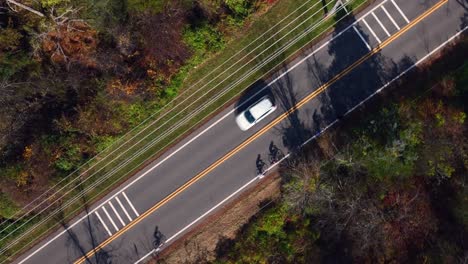 Una-Vista-Aérea-De-Gran-ángulo-Sobre-Una-Carretera-Rural-Con-árboles-Coloridos-A-Ambos-Lados-En-Un-Día-Soleado-De-Otoño