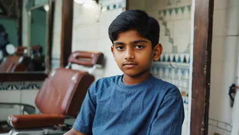 portrait of a young boy sitting in a vintage barbershop, waiting for a fresh haircut while exuding confidence and anticipation, ready for a stylish transformation