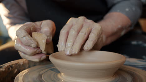 artisan creating a bowl on a pottery wheel