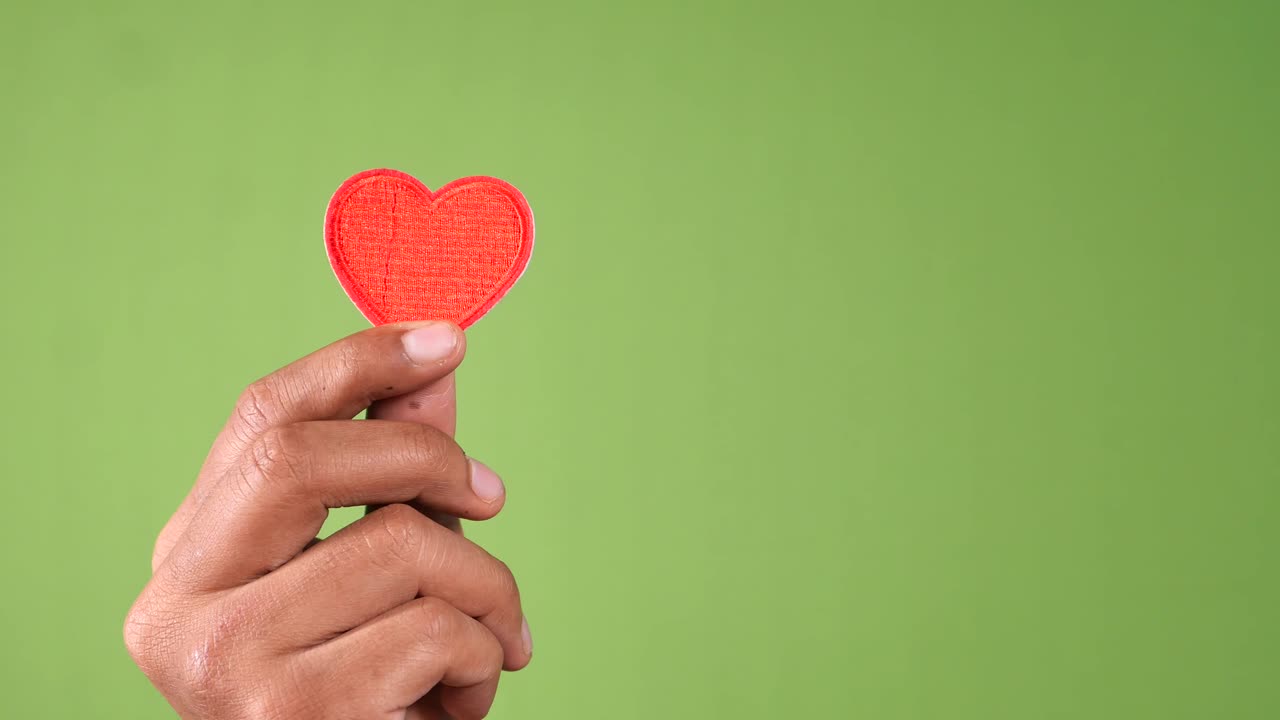 mano sosteniendo un corazón rojo