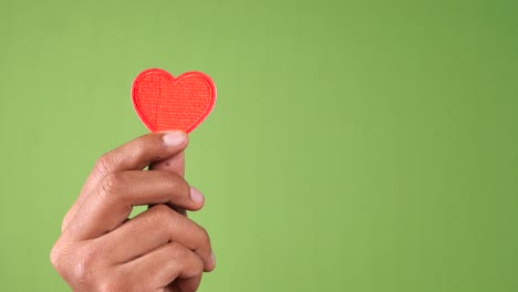 mano con un corazón rojo