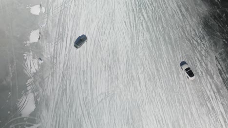 birds eye view of drifting cars that is sliding on the ice track on a frozen lake aerial 4k drone at poynette wisconsin