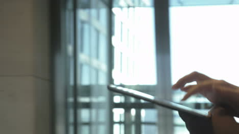 Woman-using-tablet-PC-on-the-go-indoor