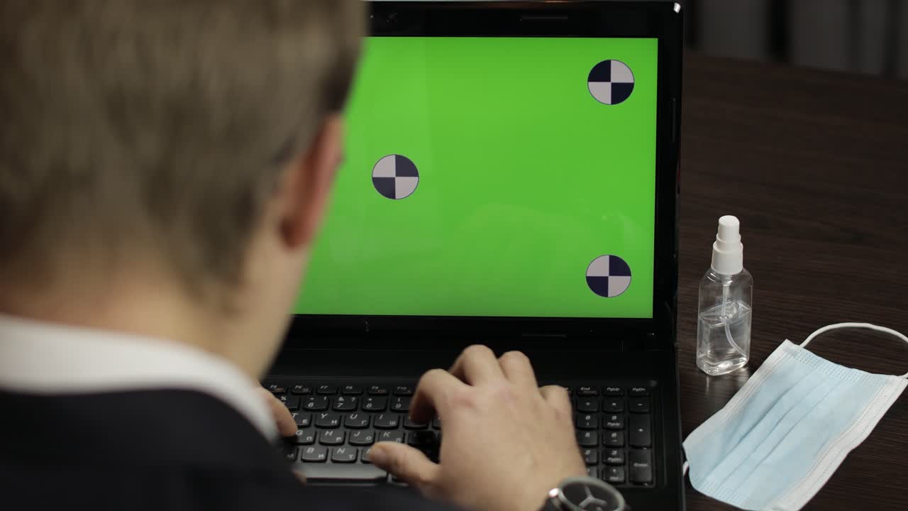 hombre está escribiendo en el teclado de la computadora portátil con pantalla verde, tecla de croma. trabajo a distancia