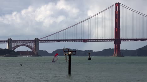 distant windsurfer speeds across san francisco bay in front of the golden gate bridge