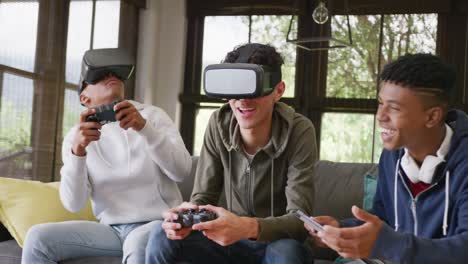 happy diverse male teenage friends playing video games and using vr headsets at home, slow motion