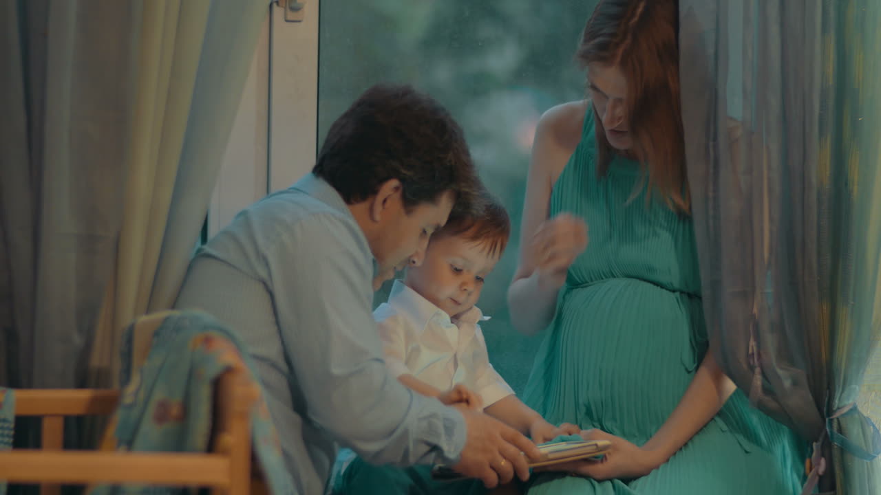 태블릿을 들고 있는 작은 소년과 그의 부모