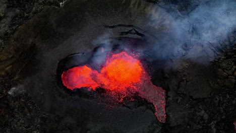 toma estática aérea cenital de la lava caliente, el magma y las cenizas que salen de la boca del cráter en fagradalsfjall, islandia