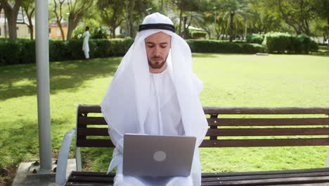 Man-sitting-on-the-bench-of-a-park