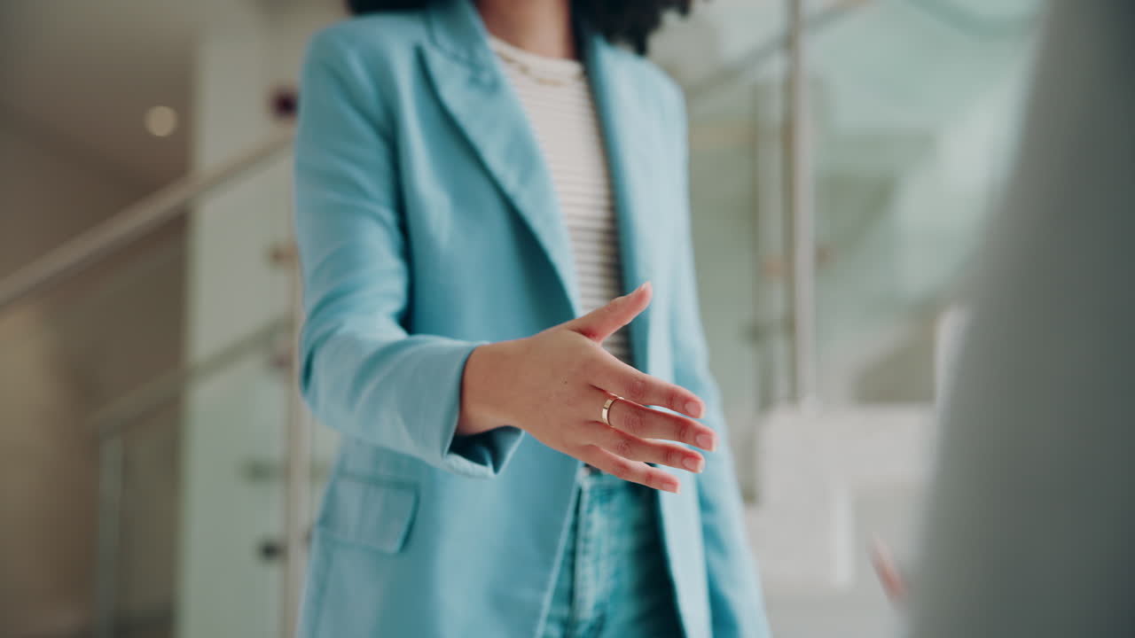 Due donne si stringono la mano in una riunione di lavoro