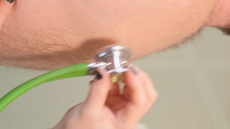 a professional doctor listens to the work of the heart with the help of a stethoscope. medical examination in the clinic.