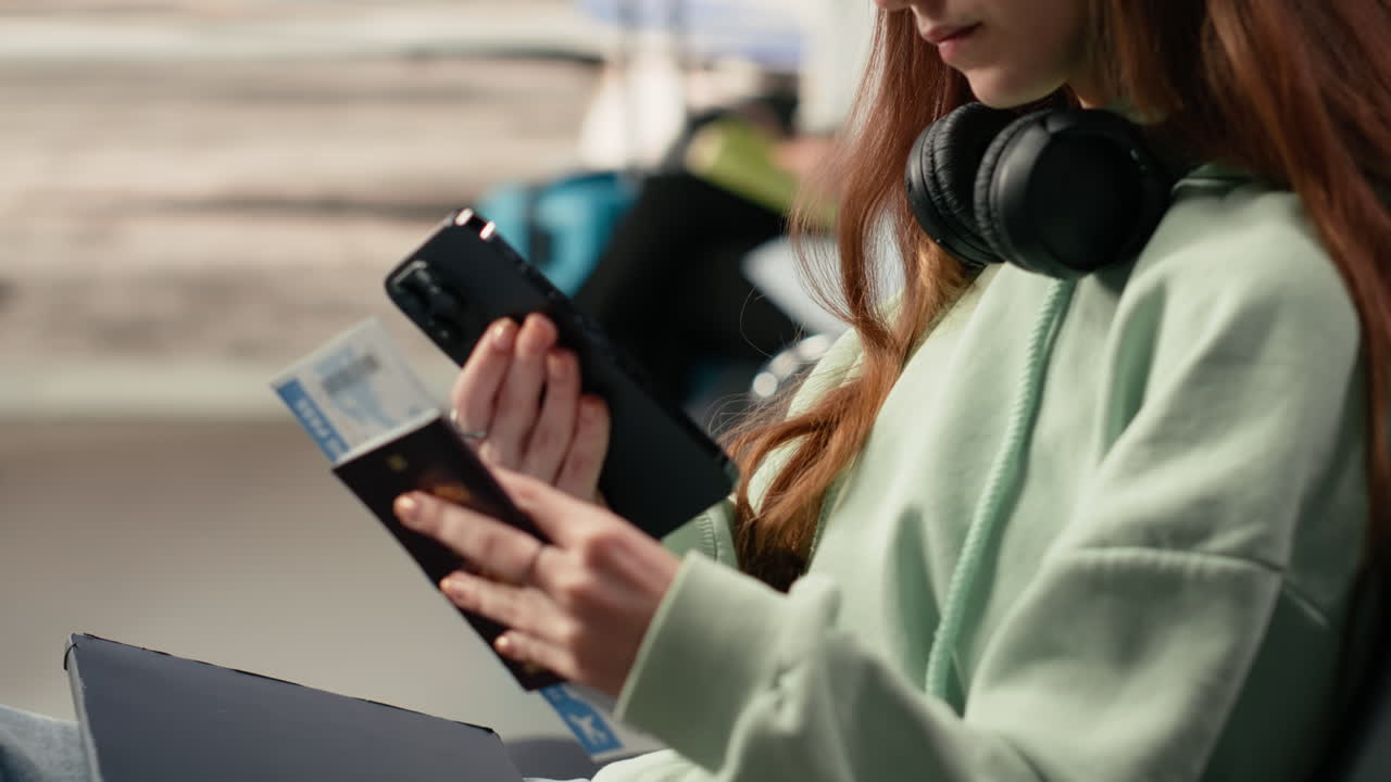 Young Woman Checking Travel Documents and Phone at Airport
