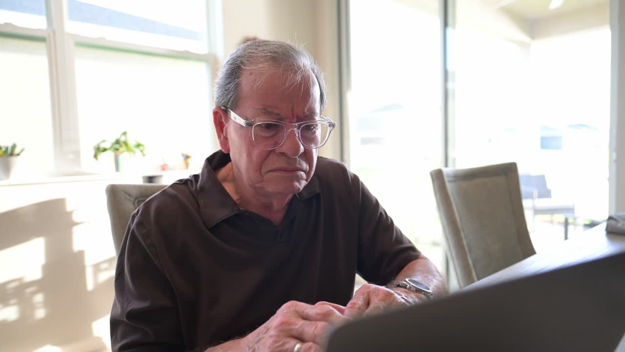 Elderly Man Struggles and Shows Frustration While Using a Laptop