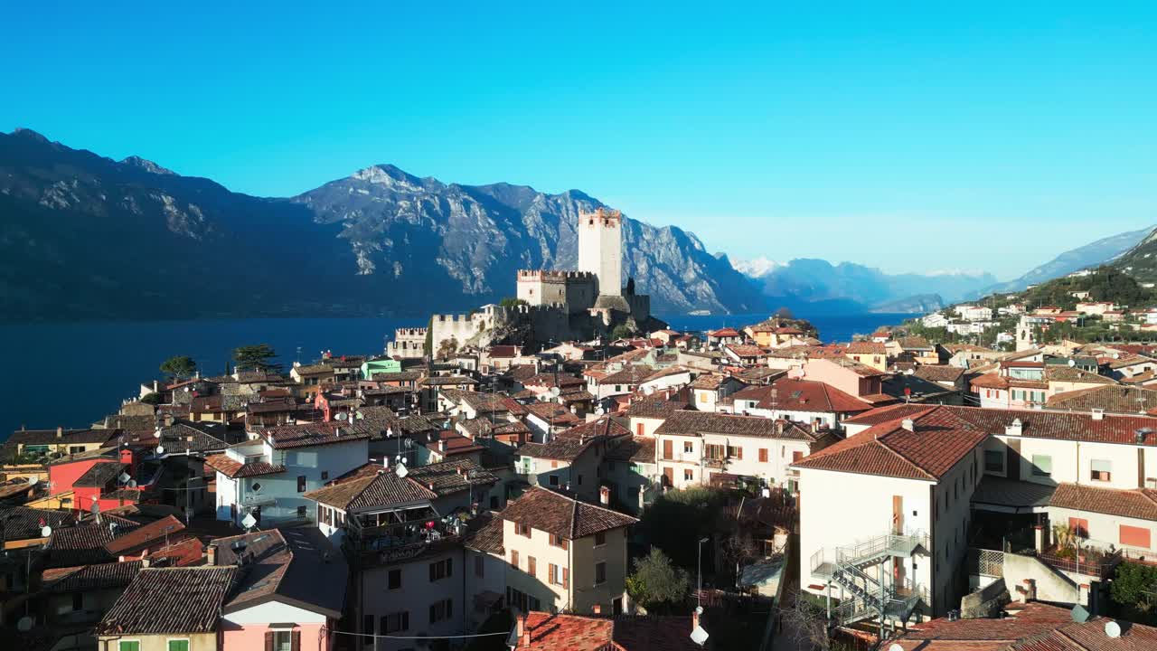 Breathtaking aerial view of Malcesine’s historic town with its iconic Scaliger Castle, nestled between Lake Garda and Monte Baldo. A must-see gem of northern Italy.