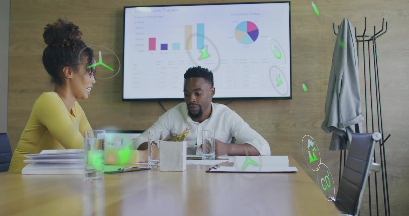 Vertical video: Woman pointing papers and man reviewing, causing eco icons covering meeting charts