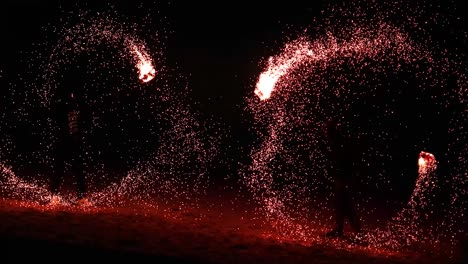 performer spinning fire at night on beach