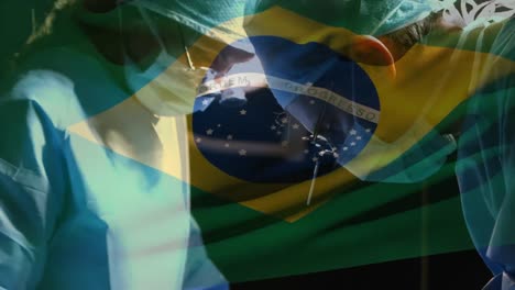 Animation-of-flag-of-brasil-waving-over-surgeons-in-operating-theatre