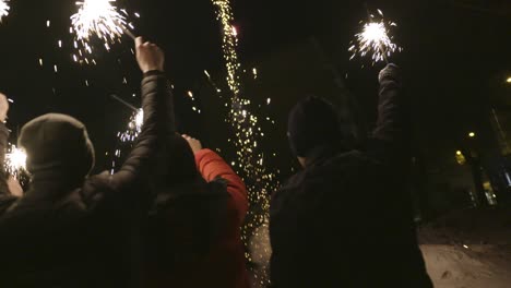 friends celebrating with sparkler at night