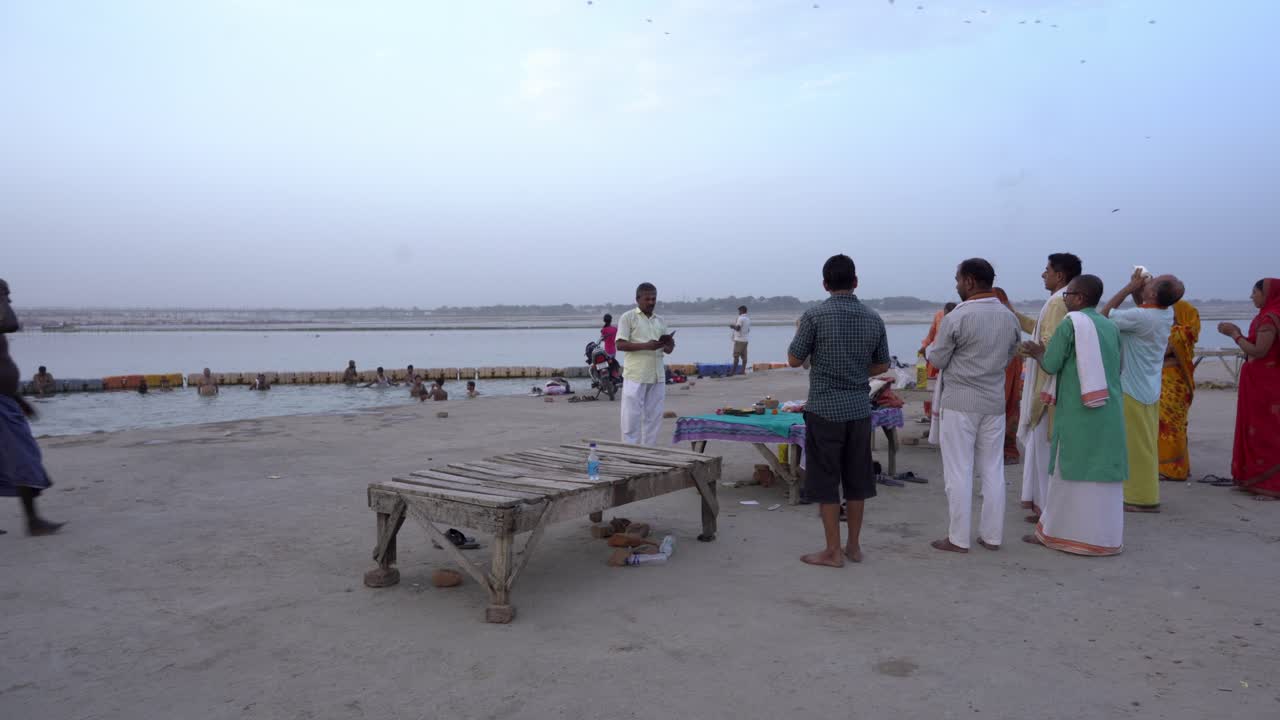 People engaging in a religious bathing ritual on an Indian river bank