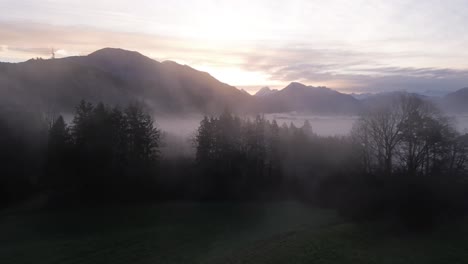 Drohne-Fliegt-über-Magischen-Nebelwald-In-Richtung-Atemberaubender-Sonnenaufgang-über-Der-Natürlichen-Berglandschaft