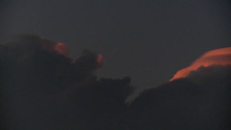 los últimos rayos del día brillan en la parte superior de las nubes en esta toma de lapso de tiempo