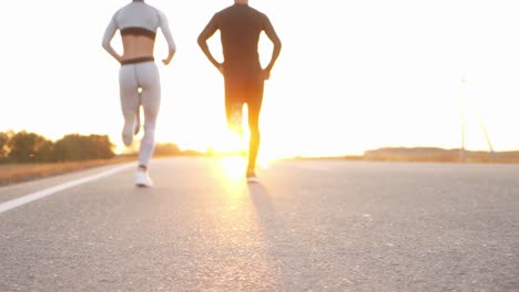 couple running on a road at sunrise/sunset