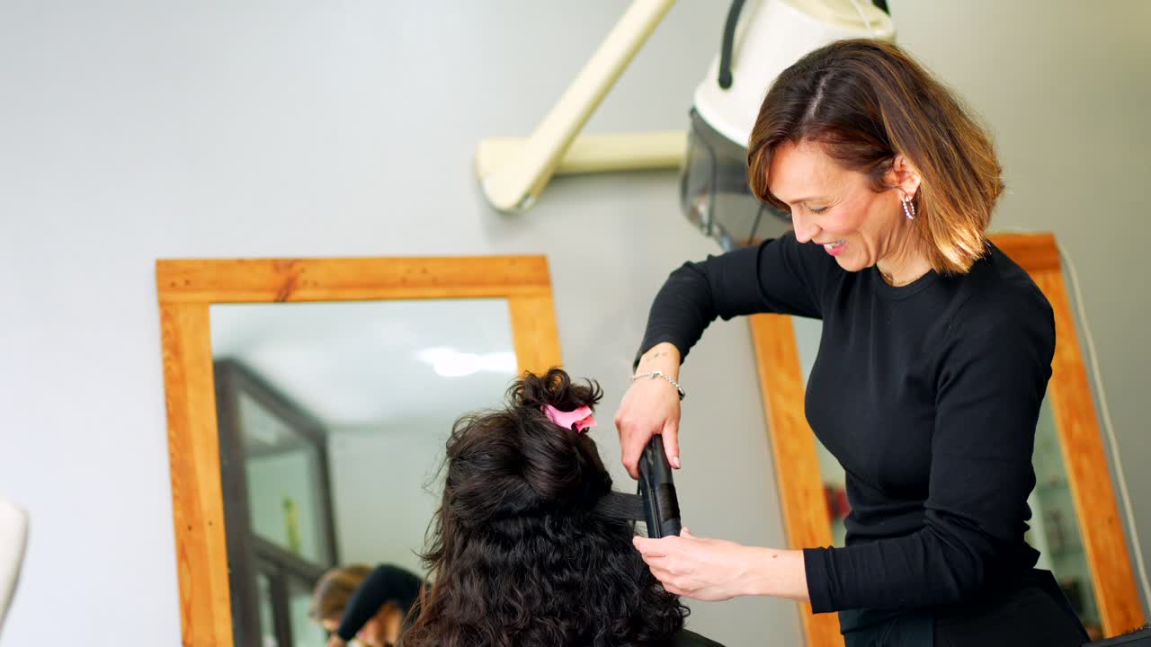 Parrucchiere che acconcia i capelli del cliente in salone