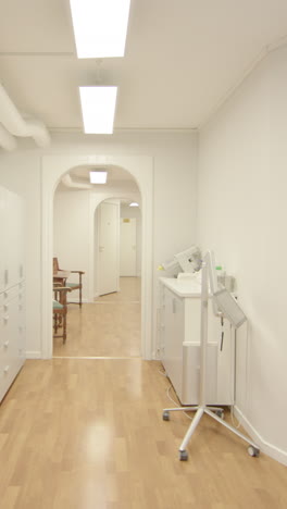 patient pov walking down medical centre corridor into dentist's office, vertical